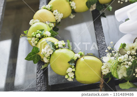Autumn wreath of ivy apples and white flowers on a door Autumn wreath of ivy apples and white flowers on a door 131489486