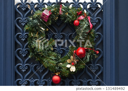 Christmas wreath with branches and red balls on a green door Christmas wreath with branches and red balls on a green door 131489492