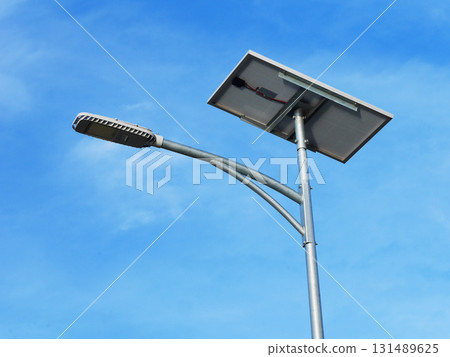 Street light powered by solar panel against clear blue sky, showcasing renewable energy technology, sustainable urban infrastructure, and eco-friendly outdoor lighting solution Street light powered by solar panel against clear blue sky, showcasing renewable energy technology, sustainable urban infrastructure, and eco-friendly outdoor lighting solution 131489625