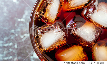 macro photo of a glass with Coca Cola and ice cubes top view 131490301