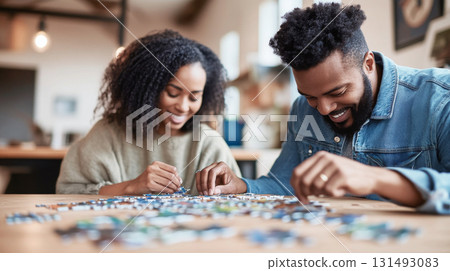 Young african american couple enjoying puzzle hobby at home, background Young african american couple enjoying puzzle hobby at home, background 131493083