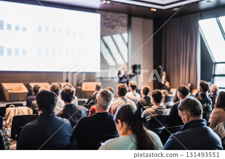 Female speaker giving a talk on corporate business conference. Unrecognizable people in audience at conference hall. Business and Entrepreneurship event Female speaker giving a talk on corporate business conference. Unrecognizable people in audience at conference hall. Business and Entrepreneurship event 131493551