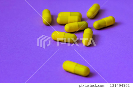 Yellow pills on on purple background background, close up Yellow pills on on purple background background, close up 131494561