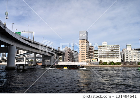 初秋的隅田川上,拖船緩緩駛過。河面上,一條高速公路蜿蜒而上。秋日的天空蔚藍遼闊。 初秋的隅田川上,拖船緩緩駛過。河面上,一條高速公路蜿蜒而上。秋日的天空蔚藍遼闊。 131494641