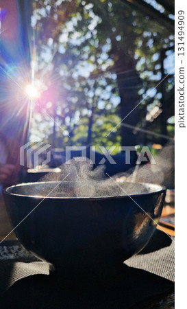 White steam rising from a cup of hot Japanese tea, symbolizing warmth, relaxation, mindfulness, and traditional tea culture. White steam rising from a cup of hot Japanese tea, symbolizing warmth, relaxation, mindfulness, and traditional tea culture. 131494909