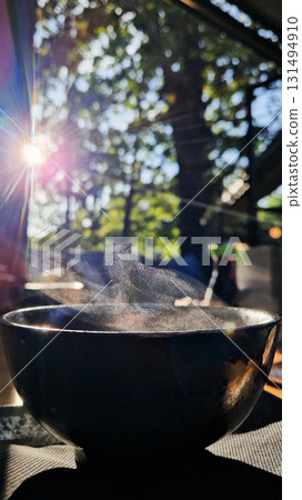 White steam rising from a cup of hot Japanese tea, symbolizing warmth, relaxation, mindfulness, and traditional tea culture. 131494910