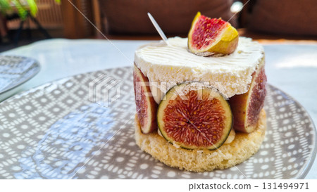 A layered dessert with a graham cracker crust, cream filling, and topped with strawberries and raspberries. Served on a decorative plate. A layered dessert with a graham cracker crust, cream filling, and topped with strawberries and raspberries. Served on a decorative plate. 131494971