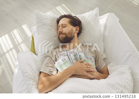 Happy relaxed wealthy man sleeping and holding his financial savings on his chest 131495218