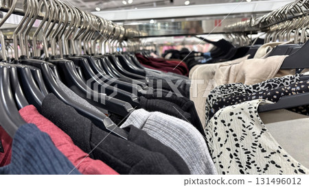 Various dresses on hangers in clothing store. Autumn and winter wardrobe preparation, seasonal fashion collection, modern apparel, stylish outfit shopping Various dresses on hangers in clothing store. Autumn and winter wardrobe preparation, seasonal fashion collection, modern apparel, stylish outfit shopping 131496012