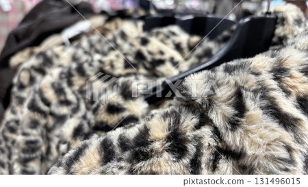 Eco friendly faux fur coats for autumn and winter on hangers in clothing store. Warm sustainable outerwear, modern fashion, wardrobe update, seasonal shopping Eco friendly faux fur coats for autumn and winter on hangers in clothing store. Warm sustainable outerwear, modern fashion, wardrobe update, seasonal shopping 131496015