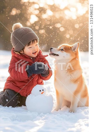 A warm and cozy winter moment: Shiba Inu and child make a snowman 131496023