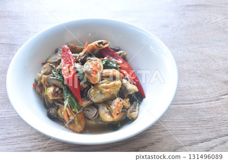 spicy stir fried mussel with chili and basil leaf in curry sauce on bowl 131496089