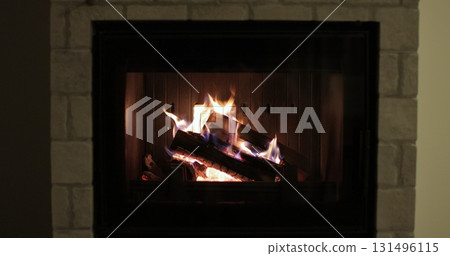 Fire in a fireplace in the cottage. Burning wood in fireplace at home. Scene is cozy and warm. Fire in a fireplace in the cottage. Burning wood in fireplace at home. Scene is cozy and warm. 131496115