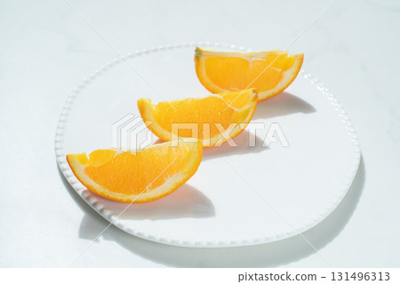 Orange on a white dish Orange on a white dish 131496313