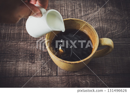 將牛奶倒入咖啡中 將牛奶倒入咖啡中 131496626