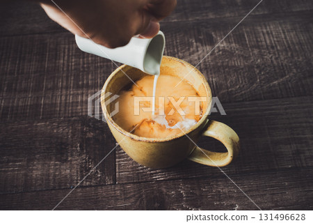 Pour milk into coffee Pour milk into coffee 131496628