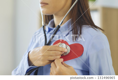 Cardiologist using stethoscope on paper heart symbolizing cardiology health care concept 131496965