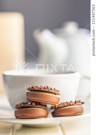 Sweet chocolate pralines. Chocolate candies and coffee cup on white table. Sweet chocolate pralines. Chocolate candies and coffee cup on white table. 131497563