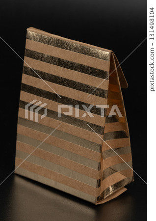 Elegant gold striped gift bag designed for special occasions 131498104