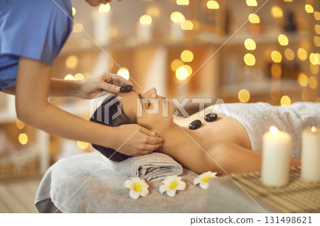 Attractive young woman enjoying hot stone spa massage Attractive young woman enjoying hot stone spa massage 131498621