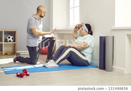 Male nurse, trainer or health care worker helping fat young woman doing fit exercises 131498656