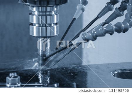 The CNC milling machine rough cutting the mold parts with oil coolant method in the light blue scene The CNC milling machine rough cutting the mold parts with oil coolant method in the light blue scene 131498706