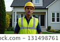 Man in yellow helmet standing in front of the house. He's wearing uniform and he's construction 131498761