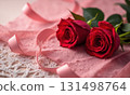 Bouquet of red roses lies on white lace tablecloth with a pink ribbon 131498764