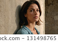 Woman model with long hair stands on concrete wall background 131498765