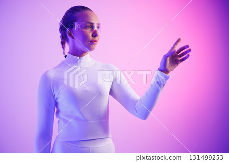 Woman in smartglasses against neon purple background 131499253