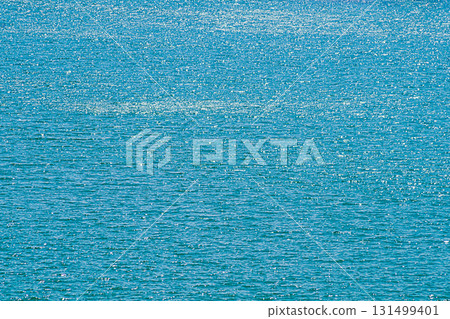 A view of the surface of the ocean or the sea with a water surface with waves with a fading perspective up the frame, there are light highlights from sunlight. Unique natural spaces 131499401