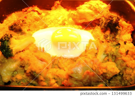 Hot and runny eggs and cheese baked in the oven 131499633