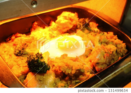 Hot and runny eggs and cheese baked in the oven 131499634