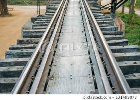 Old rail track with wooden sleepers and rusty rails 131499878