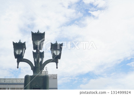 Classic street lamp silhouette against blue sky 131499924