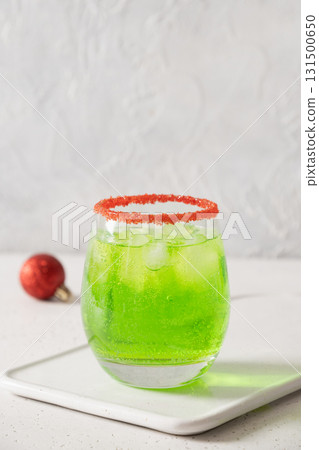 Xmas Green Punch in glass decorated red sugar rim on white table make of cool lime sherbet. Tasty drink for Christmas holiday. 131500650