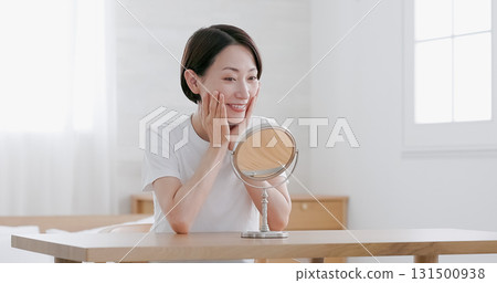 中年婦女一邊照鏡子一邊做皮膚護理 131500938