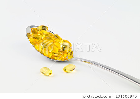 A spoonful of fish oil capsules are shown on a white background A spoonful of fish oil capsules are shown on a white background 131500979