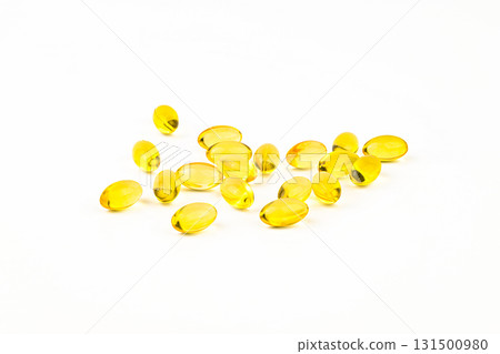 A bunch of yellow pills are scattered on a white background 131500980