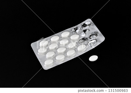 A pack of pills with a white pill in the middle 131500983