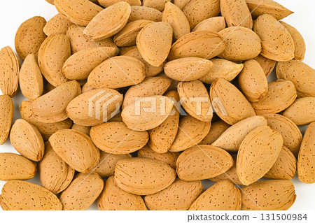 A pile of almonds with a lot of holes in them 131500984