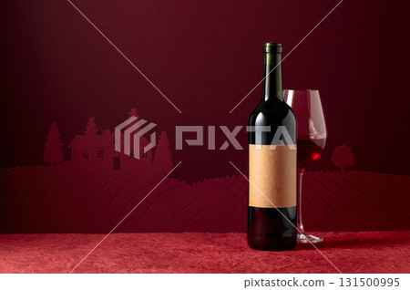 Bottle with old empty label and glass of red wine on a red background. Bottle with old empty label and glass of red wine on a red background. 131500995
