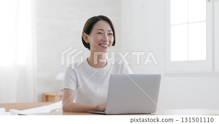 Middle-aged woman working on a laptop Middle-aged woman working on a laptop 131501110