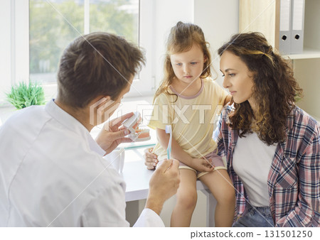 Pediatric dentist teaches daughter and mother proper toothbrush use during visit Pediatric dentist teaches daughter and mother proper toothbrush use during visit 131501250