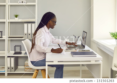 Young African American woman business accountant having online meeting via video call on laptop 131501263