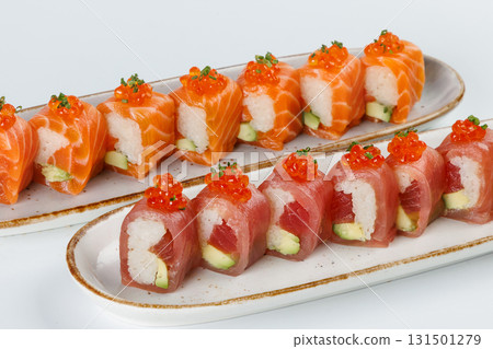 Ceramic tray with variety of salmon  end tuna sushi roll with avocado, appetizing japanese meal. 131501279