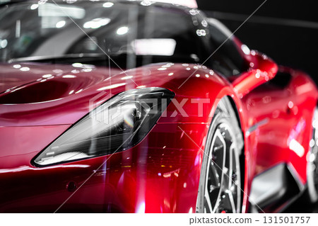 Bold Red Sports Car Front View in Showroom Spotlight, Striking Crimson Performance Vehicle Head-On at Exhibition Display Bold Red Sports Car Front View in Showroom Spotlight, Striking Crimson Performance Vehicle Head-On at Exhibition Display 131501757