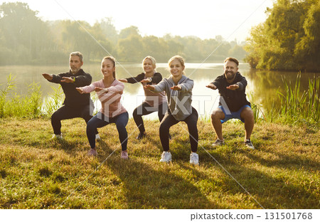 Group Of A Positive Athletes People Doing Squats In City Park 131501768