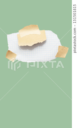 Torn piece of school notebook in a grid and brown piece of paper with beige tape on green background 131501815
