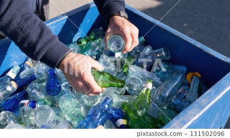 Sorting Glass Bottles For Recycling In Blue Container. Environmental Conservation And Waste Management 131502096